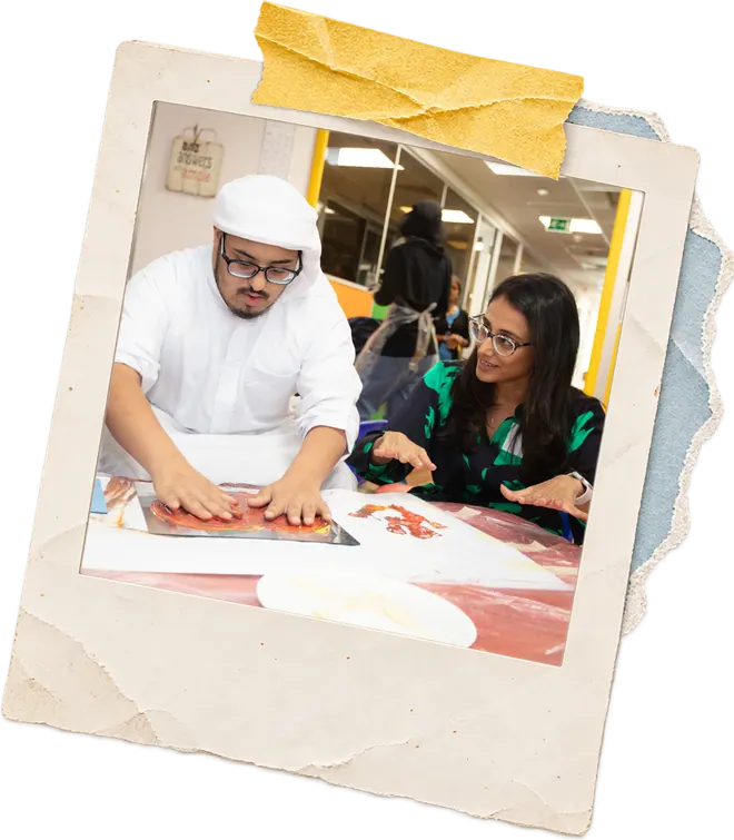 Zainab guiding a participant through a printmaking exercise in a workshop.